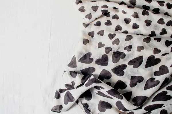black and white scarf with heart shaped pattern on white background.
