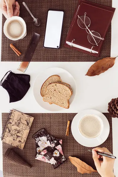 カップルのトップビュー またはホワイトテーブルのコーヒーとマスクで朝食を取る同僚 — ストック写真