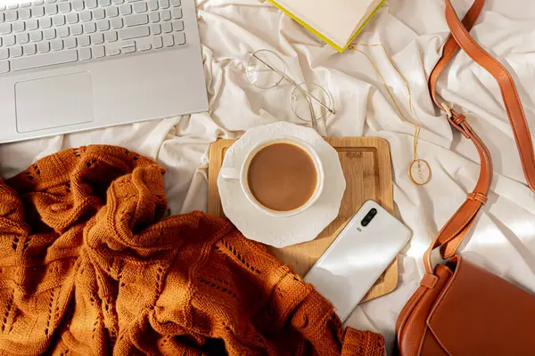 사무용품을 사무실 노트북 목걸이 스웨터 우유를 커피의 지저분한 침대에 — 스톡 사진