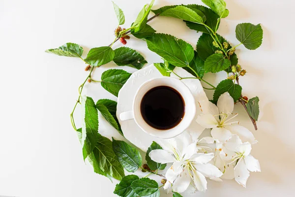 绿叶白花的黑咖啡杯的特写 — 图库照片