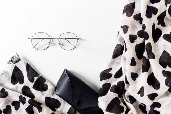 Top view of Eyeglasses, case and scarf on white background.