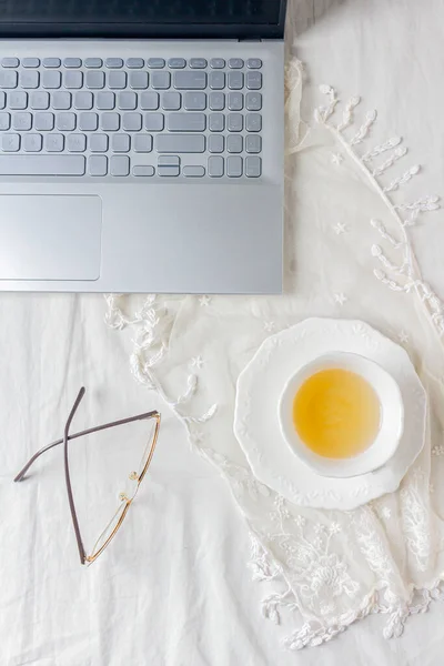 Vrouwelijke Werkruimte Laptop Kopje Thee Glazen Gedroogde Bloem Witte Kanten — Stockfoto