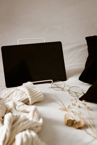 a tablet and a smartphone on the bed.