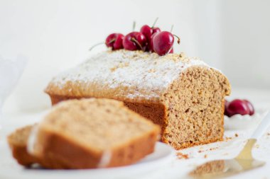 Beyaz arka planda kirazlı ev yapımı fındıklı kek. Estetik kahvaltı konsepti.