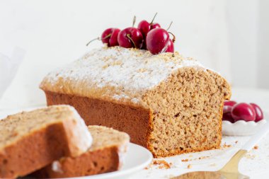 Beyaz arka planda kirazlı ev yapımı fındıklı kek. Estetik kahvaltı konsepti.