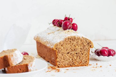 Beyaz arka planda kirazlı ev yapımı fındıklı kek. Estetik kahvaltı konsepti.