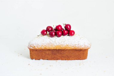 Beyaz arka planda kirazlı ev yapımı fındıklı kek. Estetik kahvaltı konsepti.