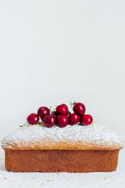 Beyaz arka planda kirazlı ev yapımı fındıklı kek. Estetik kahvaltı konsepti.