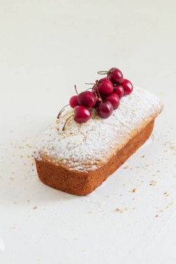 Beyaz arka planda kirazlı ev yapımı fındıklı kek. Estetik kahvaltı konsepti.
