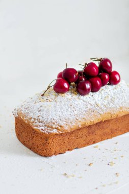 Beyaz arka planda kirazlı ev yapımı fındıklı kek. Estetik kahvaltı konsepti.