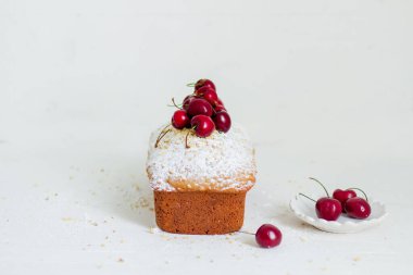 Beyaz arka planda kirazlı ev yapımı fındıklı kek. Estetik kahvaltı konsepti.