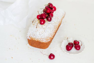 Beyaz arka planda kirazlı ev yapımı fındıklı kek. Estetik kahvaltı konsepti.