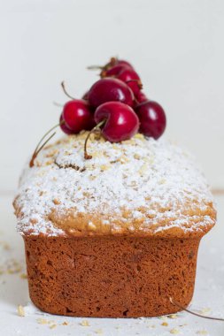 Beyaz arka planda kirazlı ev yapımı fındıklı kek. Estetik kahvaltı konsepti.