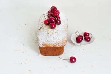 Beyaz arka planda kirazlı ev yapımı fındıklı kek. Estetik kahvaltı konsepti.