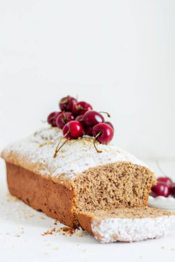 Beyaz arka planda kirazlı ev yapımı fındıklı kek. Estetik kahvaltı konsepti.