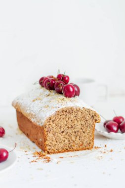 Beyaz arka planda kirazlı ev yapımı fındıklı kek. Estetik kahvaltı konsepti.