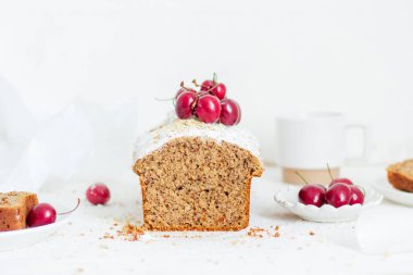 Beyaz arka planda kirazlı ev yapımı fındıklı kek. Estetik kahvaltı konsepti.