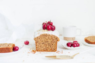Beyaz arka planda kirazlı ev yapımı fındıklı kek. Estetik kahvaltı konsepti.