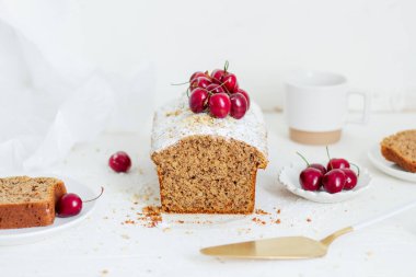 Beyaz arka planda kirazlı ev yapımı fındıklı kek. Estetik kahvaltı konsepti.