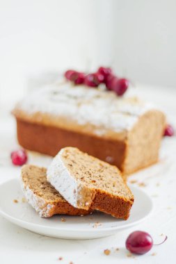 Beyaz arka planda kirazlı ev yapımı fındıklı kek. Estetik kahvaltı konsepti.