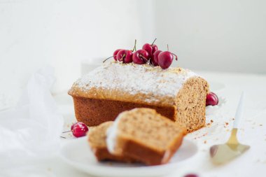 Beyaz arka planda kirazlı ev yapımı fındıklı kek. Estetik kahvaltı konsepti.