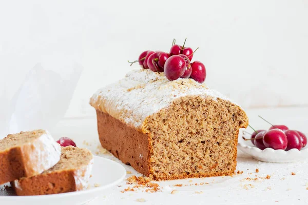 Beyaz arka planda kirazlı ev yapımı fındıklı kek. Estetik kahvaltı konsepti.