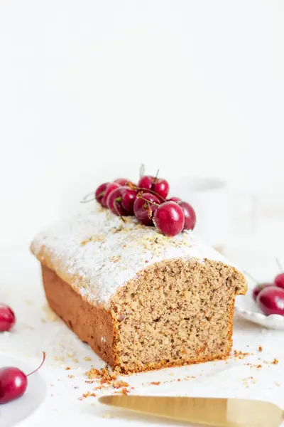 Beyaz arka planda kirazlı ev yapımı fındıklı kek. Estetik kahvaltı konsepti.