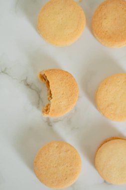 Beyaz arka planda bej bisküviler. Minimalist kompozisyon.