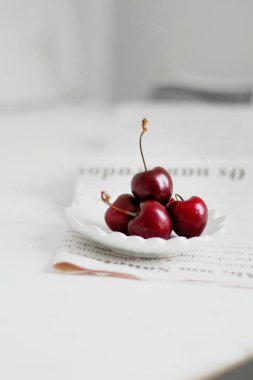 Beyaz arka planda, bir kasede vişne. Minimalist kompozisyon.