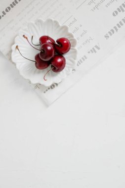 Beyaz arka planda, bir kasede vişne. Minimalist kompozisyon.