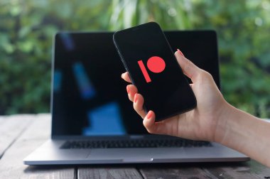WROCLAW, POLAND - 2 Ekim 2023: Patreon logosu, Amerikan kitle fonlama sitesi, arka planda MacBook Pro ile iPhone ekranında görüntülendi