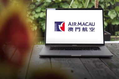 WROCLAW, POLAND - 29 Kasım 2023: Air Macau logosu, Macau bayrak taşıyıcısı, MacBook Pro ekranda sergilendi