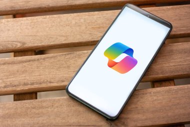 WROCLAW, POLAND - 7 Temmuz 2024: Kopilot logosu, Microsoft 365 uygulamalarına entegre edilerek verimliliği artıran bir yapay zeka asistanı ve sohbet robotu, akıllı telefon ekranında gösterilen otomatik görevler