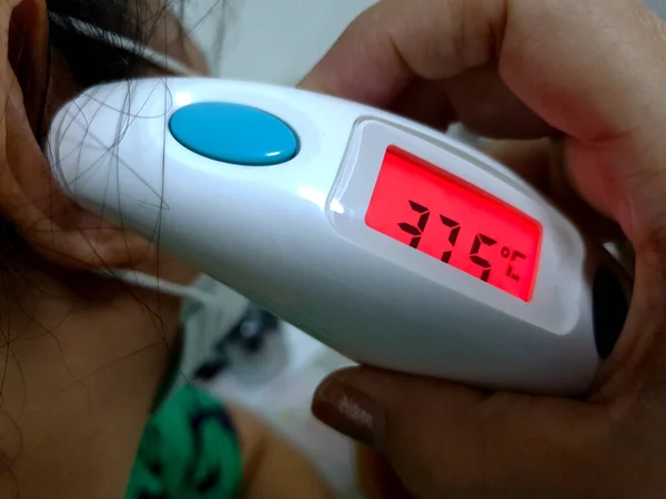 Las Mujeres Controlan Temperatura Por Termómetro Digital Oído Pantalla Muestra —  Fotos de Stock