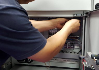 Düşük voltajlı şalter kullanan bir elektrikçinin kablo kontrol işi..