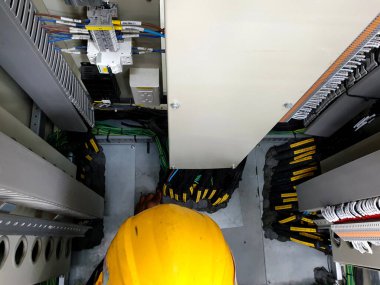 Elektrik kontrol bölmesinin zeminini mühürleyen bir işçi..