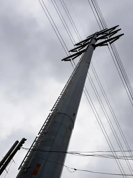 Yüksek voltajlı elektrik iletim hattı kulesi gökyüzünde bulutlar üzerinde.