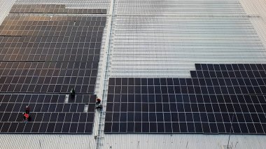 Fotovoltaik güneş panellerinin hava görüntüsü fabrika binasının çatısında çalışma etkinliği