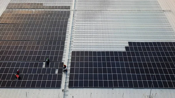 Fotovoltaik güneş panellerinin hava görüntüsü fabrika binasının çatısında çalışma etkinliği