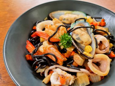 Karides, kalamar ve sebze gibi deniz ürünleriyle kaplanmış siyah kalamar. 