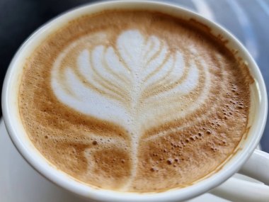 Yanda kahve dükkanı, yakın plan sıcak latte sanat kahvesi arka planı..