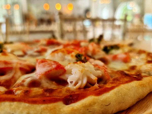 Lezzetli deniz ürünleri kokteyl pizzasının yakın çekimi.