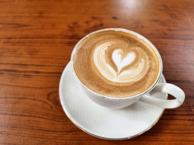 Yandan kahve, bir fincan sıcak latte sanat kahvesi, ahşap arka planda..