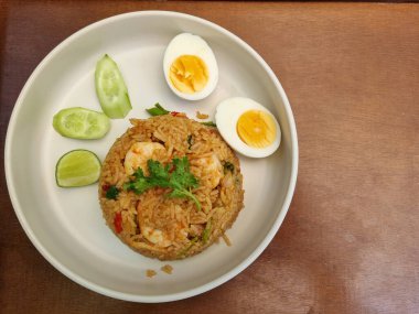 Tom Yum Fried Rice karidesli ve ahşap arka planda haşlanmış yumurta..