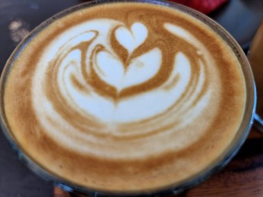 Yanda kahve dükkanı, yakın plan sıcak latte sanat kahvesi arka planı..