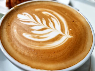Yanda kahve dükkanı, yakın plan sıcak latte sanat kahvesi arka planı..