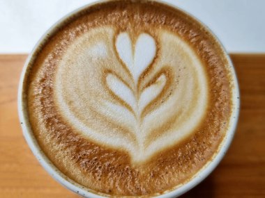Yanda kahve dükkanı, yakın plan sıcak latte sanat kahvesi arka planı..