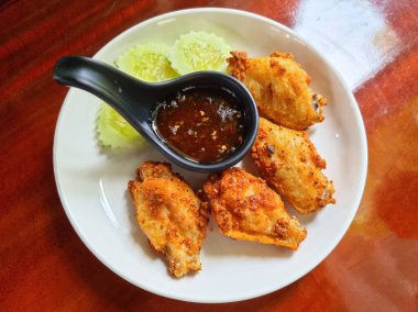 Ahşap masada tatlı soslu kızarmış tavuk kanadı..