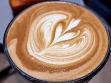 Yanda kahve dükkanı, yakın plan sıcak latte sanat kahvesi arka planı..