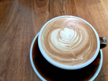 Yandan kahve, bir fincan sıcak latte sanat kahvesi, ahşap arka planda..
